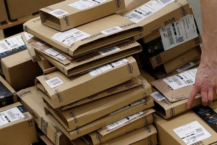 Trends in Online retail demand a worker sorts parcels at amazon's fulfilment centre in peterborough
